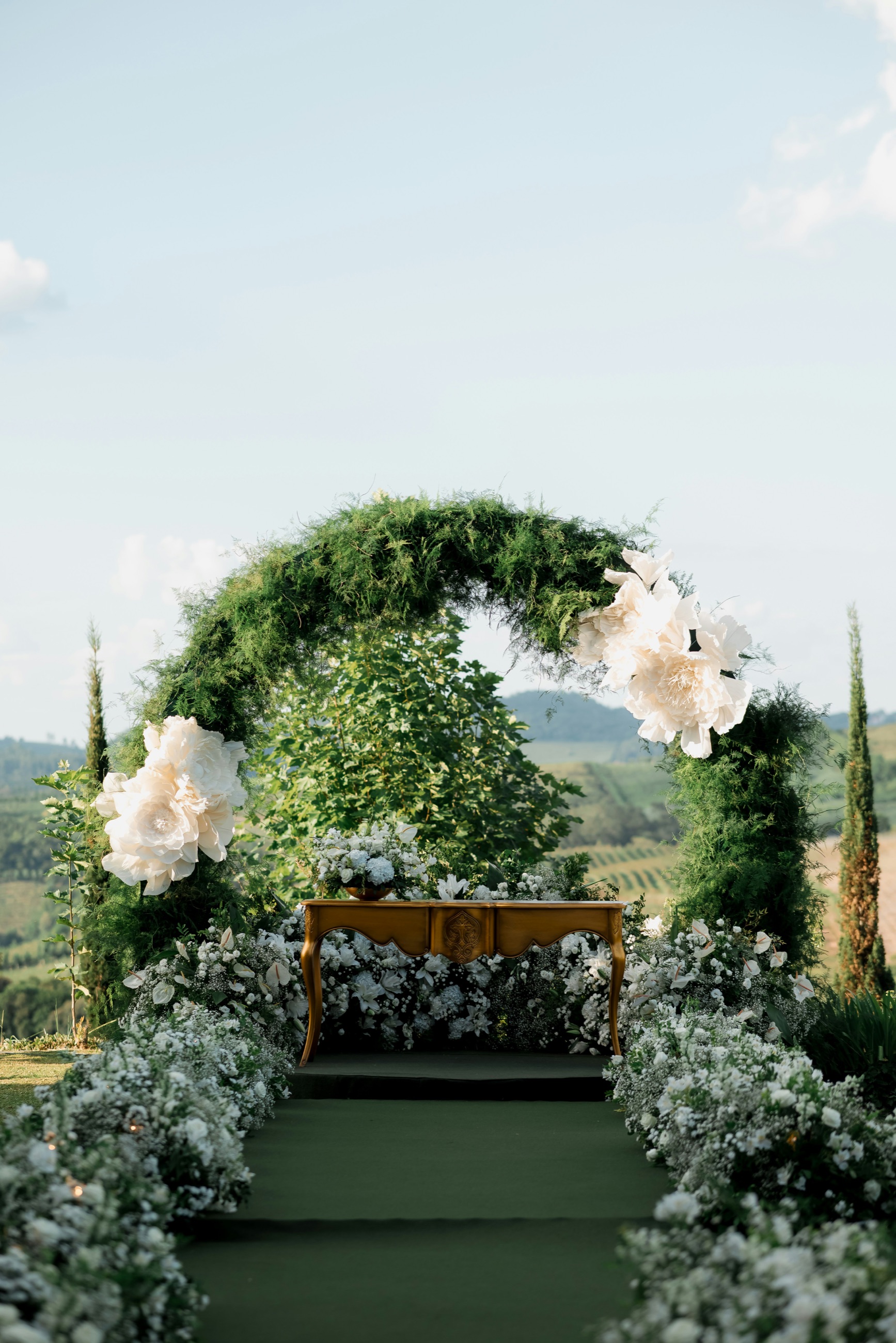 Outdoor wedding ceremony arch with floral installation